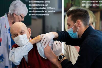 Nurses vaccinate Leon T, aged 80, as he becomes the first person in Geneva to receive the Pfizer-BioNtech vaccine in Switzerland. AP Photo