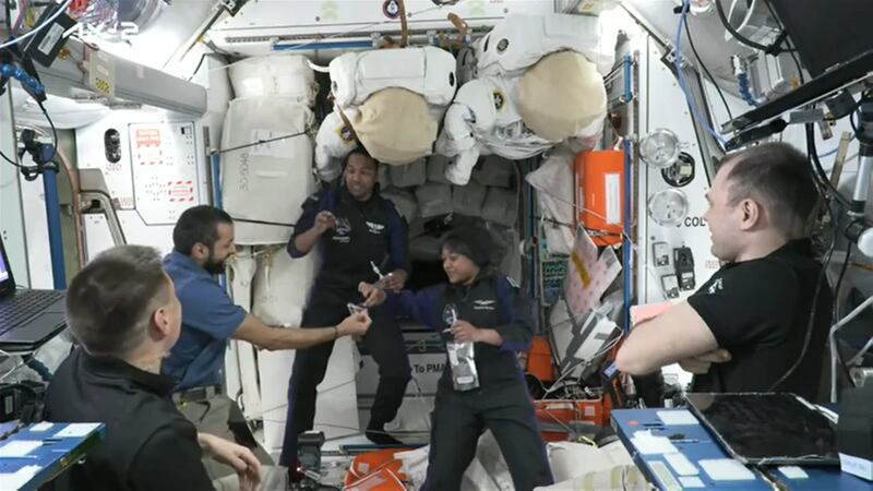 Mr Al Neyadi offers water and dates to the two Saudi astronauts after their arrival 