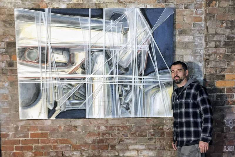 Jared Whipple stands next to a painting by Francis Hines that was found in a dumpster. AP