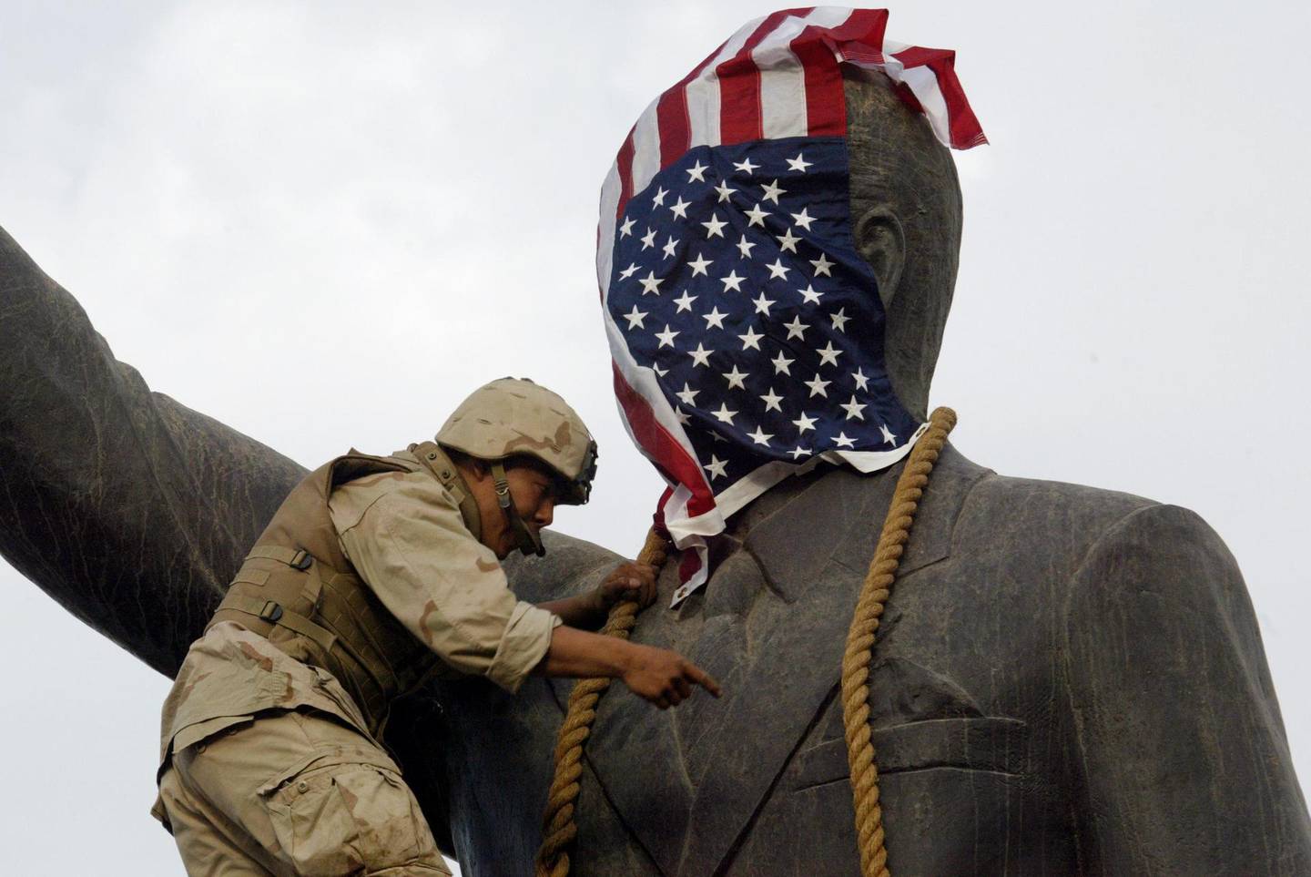 (FILES) In this file photo taken on April 9, 2003 A US Marine covers the head of a statue of Iraqi President Saddam Hussein with the US flag before pulling it down in Baghdad's al-Fardous (paradise) square as the marines swept into the Iraqi capital and the Iraqi leader's regime collapsed.
On April 9, 2003, the US-led coalition overthrew Saddam Hussein. Fifteen years after the invasion, life in Iraq has been transformed as sectarian clashes and jihadist attacks have divided families and killed tens of thousands of people, leaving behind wounds that have yet to heal and a lagging economy. / AFP PHOTO / RAMZI HAIDAR