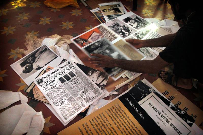 In this Aug. 12, 2017 photo, a worker sorts through photographs, newspaper clippings, and other material that will cover the walls at the Partition Museum, set to open in Amritsar, India, 32 kilometres (20 miles) from border with Pakistan. India's first partition museum tells the stories of those who survived the chaos and bloodshed 7 decades ago. (AP Photo/Rishabh R. Jain)