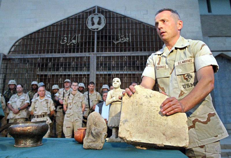US Colonel Matthew Bogdanos, lead investigator in finding looted treasures taken from the Baghdad Archeological Museum, directs a presentation to the press in Baghdad, 16 May 2003. Investigators have recovered 951 artifacts and determined many items had been stored for their security in pre-war hidding sites. One of the oldest known bronze relief bowls, an Assiryan pottery jar from the sixth millenium B.C., one of the earliest known Sumerian free-standing statue and a carved rock from the Babilonic period were pesented to the press.    AFP PHOTO/Behrouz MEHRI / AFP PHOTO / BEHROUZ MEHRI