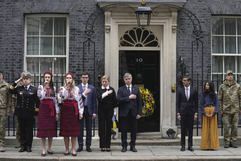 Britain's Prime Minister Rishi Sunak and his wife Akshata Murty, with Ukrainian ambassador to the UK Vadym Prystaiko, centre, his wife Inna and members of the Ukrainian Armed Forces outside 10 Downing Street in London, as they observe a minute's silence. AP