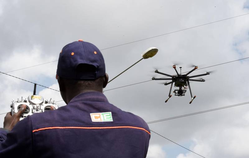 (FILES) In this file photo taken on July 10, 2017 an employee of the Ivorian Electricity company (CIE) pilots a drone that ensures the monitoring of the hight voltage electric network at the Centre des Metiers de l'Electricite (Electricity Professional Center) in Bingerville, near Abidjan.
Ivory Coast, one of the African leaders in electricity, announced on July 6 a project to use drones to monitor its 5,000 km of high voltage lines, seeing "a solution that is essential." / AFP PHOTO / SIA KAMBOU