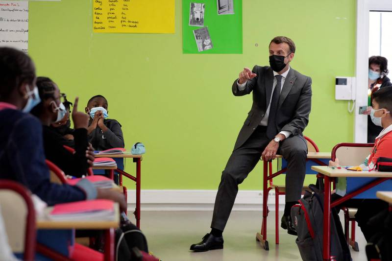 French President Emmanuel Macron addresses pupils during a visit to a primary school in Melun, as French primary schools and kindergartens reopen after three-week closure amid the Covid-19 pandemic. AFP