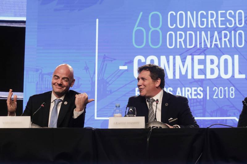 FIFA President Gianni Infantino, left, talks with Alejandro Dominguez, right, president of the South American Football Confederation, CONMEBOL, during their annual conference in Buenos Aires, Argentina, Thursday, April 12, 2018. CONMEBOL has asked FIFA to expand the World Cup to 48 teams for the 2022 tournament in Qatar. (AP Photo/Martin Ruggiero)