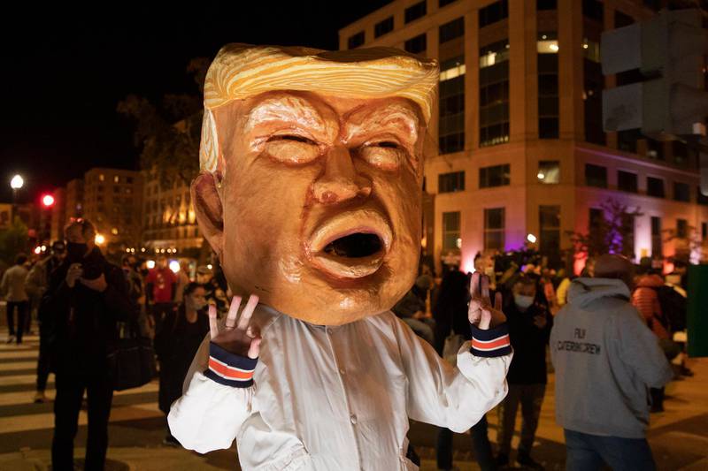 A woman wears a mask depicting US President Donald Trump at Black Lives Matter Plaza in Washington, DC.  EPA