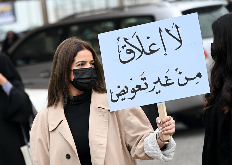 A business owner carries a placard that reads 'No closure without compensation' during a protest in Kuwait City against the closure of salons and health clubs in Kuwait as a measure to stem the spread of the coronavirus. EPA