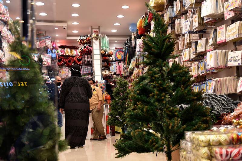 People walk past christmas decorations set up for display at a shop in the Swailem market in Riyadh. AFP