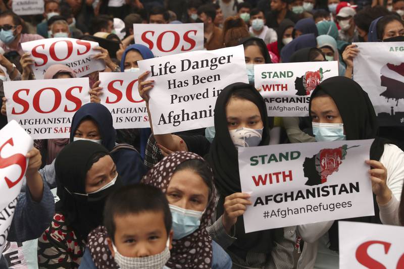 Afghan refugees  living in Indonesia hold posters during a rally outside the building that houses UNHCR representative office in Jakarta, Indonesia, Tuesday, Aug.  24, 2021.  The protesters were mostly members of the Hazara ethnic minority. AP