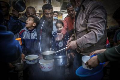 Gaza City residents gather round as Palestinian Walid al-Hattab serves up soup during the coronavirus-affected Ramadan. AFP