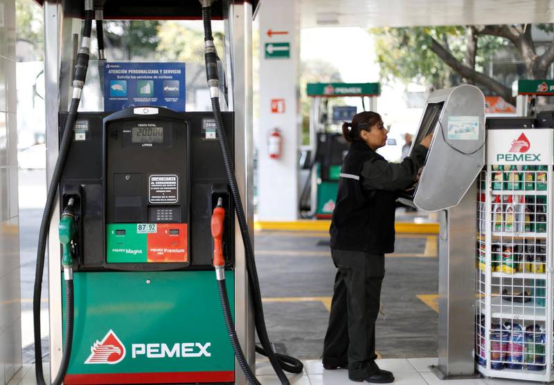 FILE PHOTO: An employee makes a payment next to fuel pumps at a Pemex gas station in Mexico City, Mexico February 8, 2018. REUTERS/Edgard Garrido/File Photo