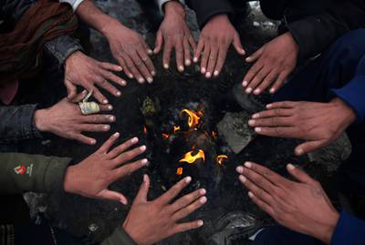 People sit around a fire to warm themselves after a heavy snowfall in Kabul, Afghanistan. AP Photo