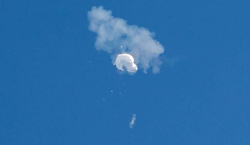 A suspected Chinese spy balloon drifts to the ocean after being shot down off the US's eastern coast. Reuters