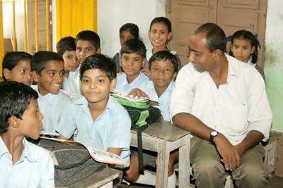 Mamoon Akhtar, the founder of Samaritan Help Mission, joins students at one of its schools. Courtesy Samaritan Help Mission
