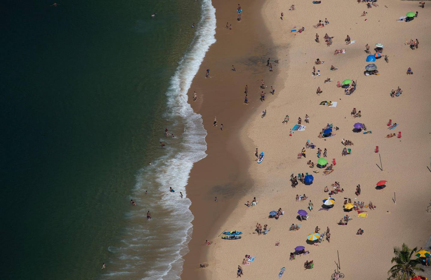 People enjoy Red beach amid the new coronavirus pandemic in Rio de Janeiro, Brazil, Wednesday, Aug.12, 2020. (AP Photo/Silvia Izquierdo)