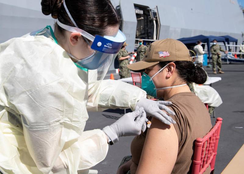A United States Navy officer from the amphibious ship USS San Diego (LPD 22) receives a vaccine against Coronavirus (COVID-19) at the navy port in Manama, Bahrain in this picture taken February 26, 2021 and released by U.S Navy on February 27, 2021. Brandon Woods/U.S. Navy/Handout via REUTERS ATTENTION EDITORS- THIS IMAGE HAS BEEN SUPPLIED BY A THIRD PARTY.