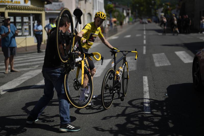 Overall race leader Jonas Vingegaard changes bikes after crashing during the stage. AP