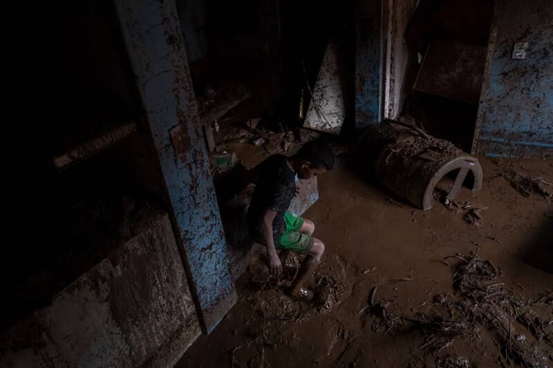 A child walks through his mud-filled home in Tejerias. EPA