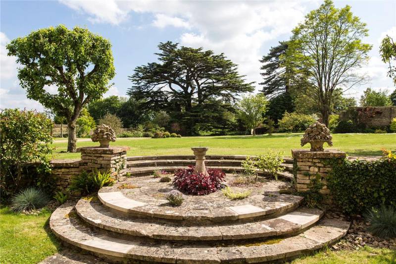 The grounds at Luckington Court include paved terraces, pergolas, a croquet lawn, a rose garden and a Roman-inspired portico.