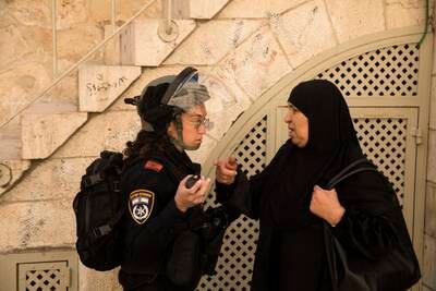 An Israeli police officer stops a Muslim woman on her way to Friday prayer in Jerusalem.  Getty Images