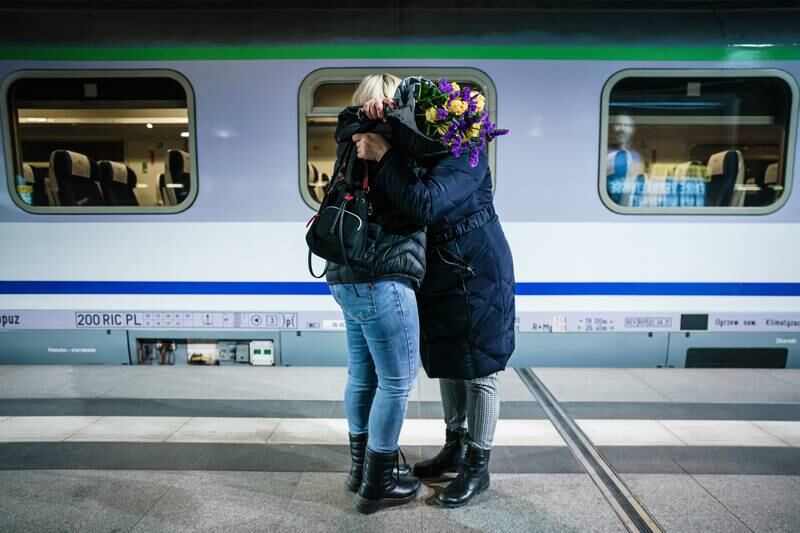 A woman (right) hugs an arriving passenger from a train carrying refugees at Berlin's central station. EPA