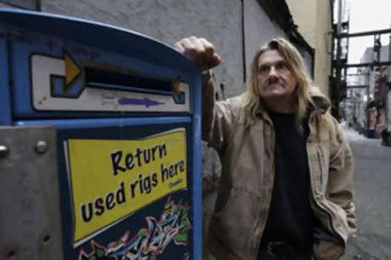 Earl Crowe, a former heroin user who used the Insite safe injection site, stands near a needle disposal unit in Vancouver, British Columbia.