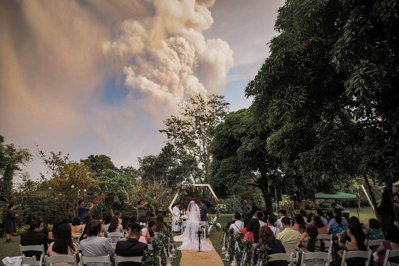 People attend a wedding ceremony as Taal Volcano sends out a column of ash in the background in Alfonso, Cavite, Philippines, January 12, 2020, in this image obtained from social media. Courtesy of Randolf Evan Photography/Social Media via REUTERS. ATTENTION EDITORS - THIS IMAGE HAS BEEN SUPPLIED BY A THIRD PARTY. MANDATORY CREDIT CREDIT RANDOLF EVAN PHOTOGRAPHY. NO RESALES. NO ARCHIVES.