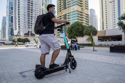 DUBAI, UNITED ARAB EMIRATES. 26 OCTOBER 2020. E-scooter trials rolled out in five areas across city for a year long project for commuters to rent and use e-scooters while commuting to and from tram and metro stations. A resident who did not want to give his name checks out one of the scooters for rent at the DMCC Metro Station in JLT. (Photo: Antonie Robertson/The National) Journalist: Kelly Clarke. Section: National.