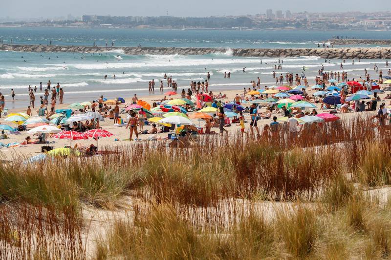 People enjoy a sunny day at the beach in Costa da Caparica, Almada, Portugal. EPA