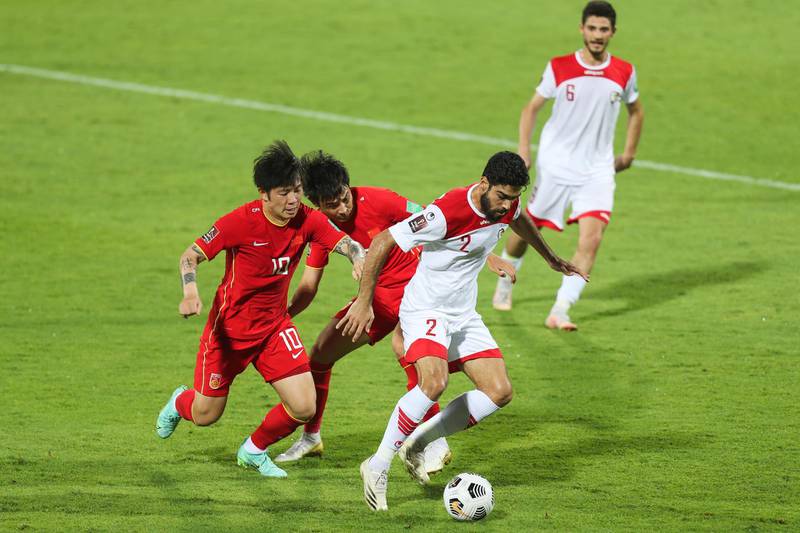 China's Zgang Xizhe and Wu Xinghan work to regain possession from Syria's midfielders at the UAE's Sharjah Stadium. Getty Images