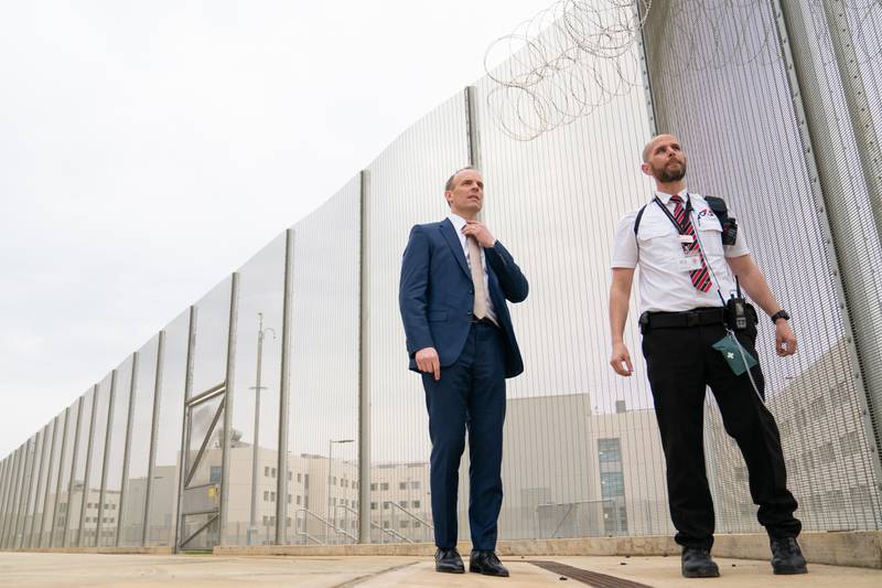 Deputy Prime Minister and Justice Secretary Dominic Raab, left, with a prison officer at the opening of category C prison HMP Five Wells in Wellingborough. PA