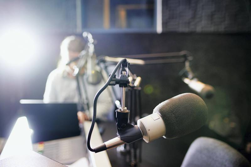 Shot of a microphone in a recording studio with the presenter blurred in the background
