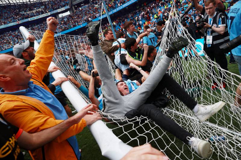 Manchester City fans celebrate on the pitch after winning the Premier League following their match against Aston Villa at the Etihad Stadium, on May 22, 2022. Reuters