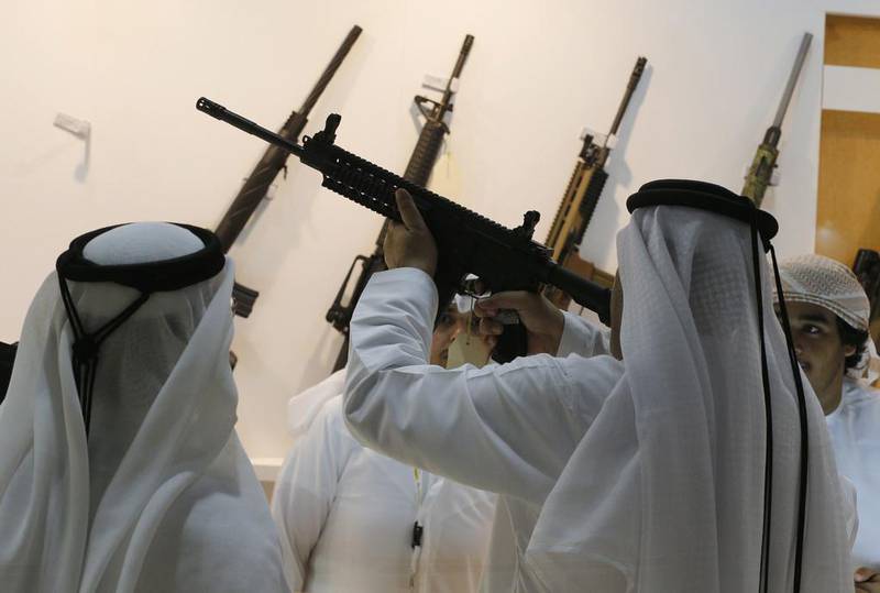 Emirati men look at weapons during the first day of ADIHEX. Karim Sahib / AFP Photo