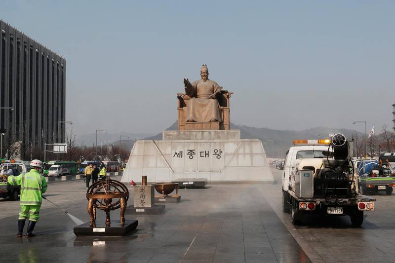 A worker and vehicle spray disinfectant and water as a precaution against the new coronavirus in front of the statue of King Sejong in the Joseon Dynasty, at the Gwanghwamun Plaza in Seoul, Thursday, Feb. 20. The mayor of the South Korean city of Daegu urged its 2.5 million people on Thursday to refrain from going outside as cases of the new virus spike. (AP Photo/Ahn Young-joon)