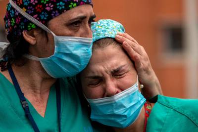 Health workers cry during a memorial for their co-worker Esteban, a nurse who died, at the Severo Ochoa Hospital in Leganes in Leganes, Spain, on April 10, 2020.  AP Photo