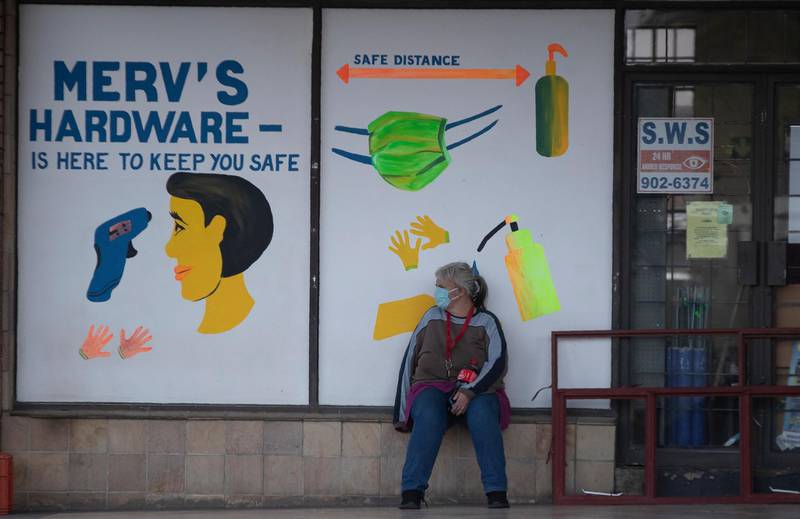 A woman sits outside a hardware shop in Johannesburg, South Africa. AP Photo
