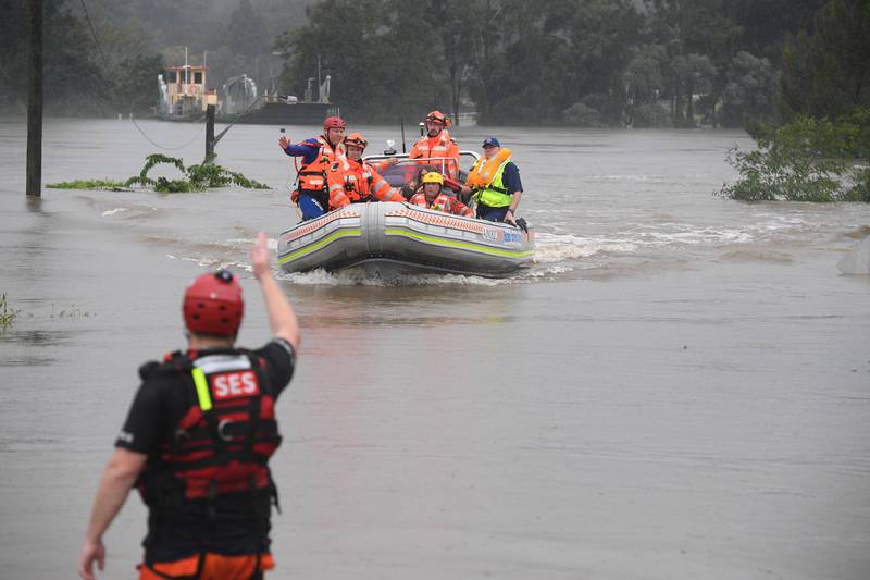 epa09090807 A family is rescued after their boat capsized as they were being evacuated from a flooded property at Upper Colo in north western Sydney, New South Wales (NSW), Australia, 23 March 2021. Thousands were evacuated in New South Wales as the state experienced its worst flooding in decades.  EPA/DEAN LEWINS AUSTRALIA AND NEW ZEALAND OUT
