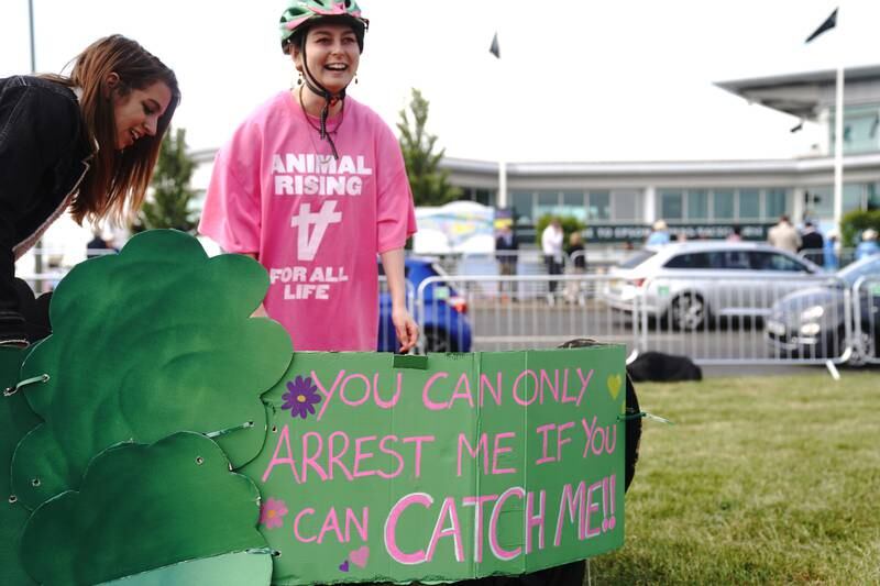 A member of Animal Rising holds a sign during a protest outside Epsom racecourse on Saturday as tens of thousands flocked to watch the Derby. PA  