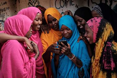 Young Somali refugee women look at a smartphone as they stand together at Dadaab refugee complex, in the north-east of Kenya, on April 16, 2018. - The Dadaab refugee complex which has some 235269 refugees and asylum seekers in four camps about 80kms from the Somali-Kenyan border was established in 1991, according to UNHCR camp population statistics in January 2018. (Photo by Yasuyoshi CHIBA / AFP)