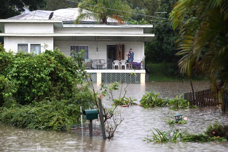 A resident watches floodwaters from his house in Ipswich. EPA