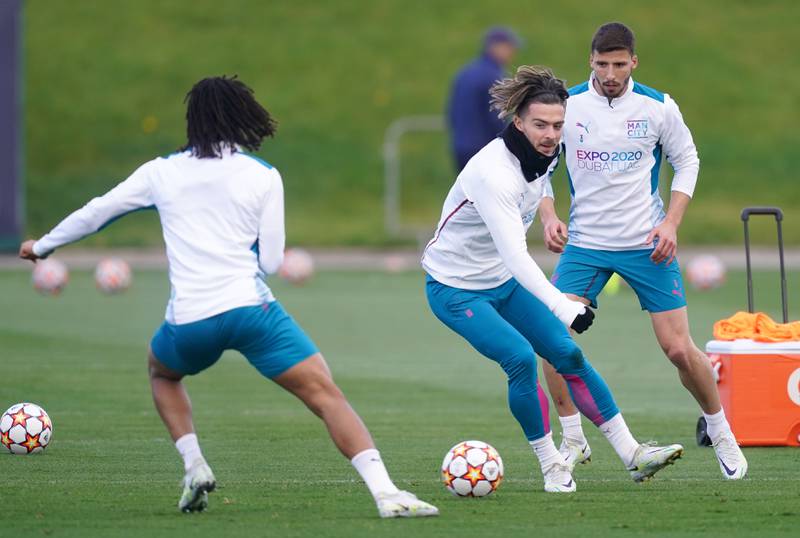 Manchester City's Nathan Ake, left, Jack Grealish, centre, and Ruben Dias during a training session on Monday. PA