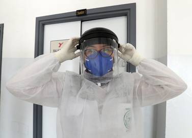 Abir Mdini, a doctor at Tunisia’s emergency medical aid service, or SAMU, dons protective equipment before visiting patients with the coronavirus in Tunis. EPA