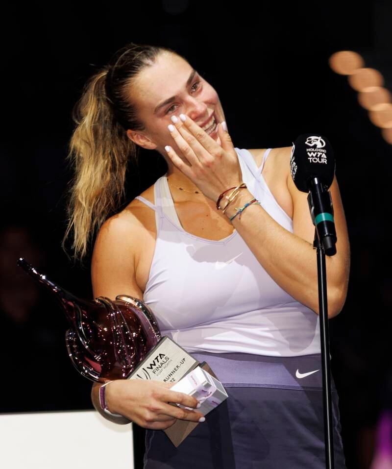 Aryna Sabalenka wipes tears as she holds the runner-up trophy following her loss to Caroline Garcia in the WTA Finals. EPA