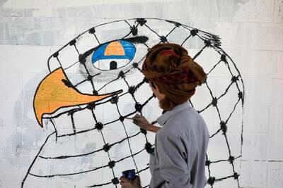 A Yemeni artist paints graffiti on a wall in Sanaa in solidarity with Palestinians. EPA