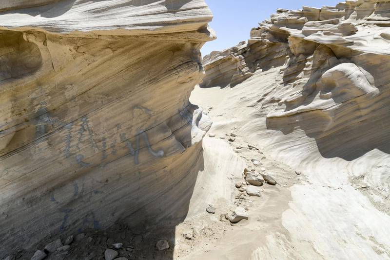 Abu Dhabi, United Arab Emirates - Graffiti vandalism near the entrance of the ancient rock formations attraction in the outskirts desert area, at Al Wathba. Khushnum Bhandari for The National