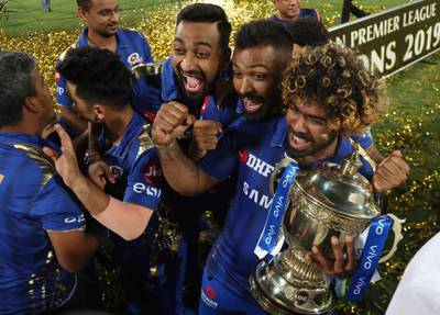 Mumbai Indians' Lasith Malinga, right, and teammates celebrate with the trophy after their win over Chennai Super Kings in the final cricket match of VIVO IPL T20 in Hyderabad, India, early Monday, May 13, 2019. Mumbai Indians won the match by one run. (AP Photo/ Mahesh Kumar A.)