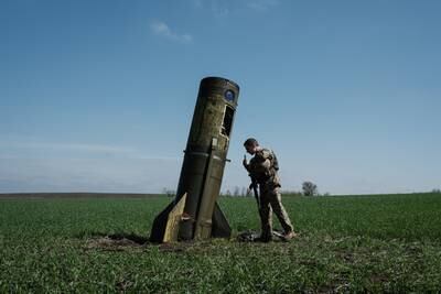 A Ukrainian serviceman looks at a Russian ballistic missile's booster stage that fell in a field in Bohodarove, eastern Ukraine, on April 25. AFP