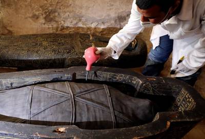 An archaeologist works on a sarcophagus. Reuters